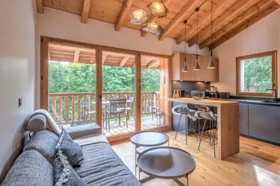 a living room and kitchen with a couch and a table at Appartement Crystal - 4 étoiles - Welkeys in Megève