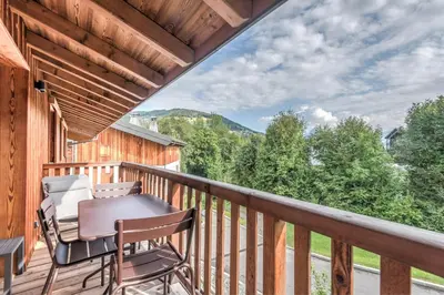 a balcony with a table and chairs and a view at Appartement Crystal - 4 étoiles - Welkeys in Megève