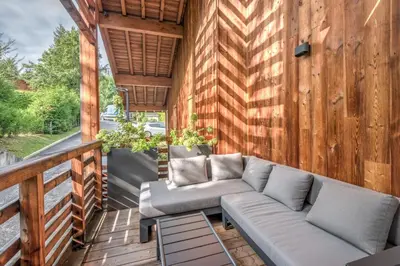 a porch with a couch on a wooden deck at Appartement Crystal - 4 étoiles - Welkeys in Megève