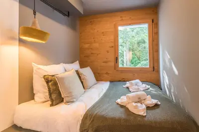 a bedroom with a bed with a teddy bear on it at Appartement Crystal - 4 étoiles - Welkeys in Megève