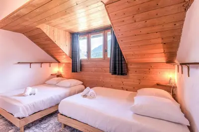 two beds in a room with a wooden ceiling at Appartement du Rosay - Welkeys in Saint-Gervais-les-Bains