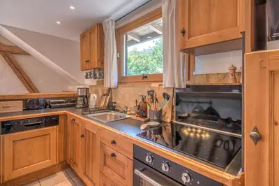 a kitchen with wooden cabinets and a sink at Appartement du Rosay - Welkeys in Saint-Gervais-les-Bains