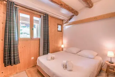 a bedroom with a bed and a window at Appartement du Rosay - Welkeys in Saint-Gervais-les-Bains