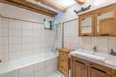 a bathroom with a sink and a bath tub at Appartement du Rosay - Welkeys in Saint-Gervais-les-Bains