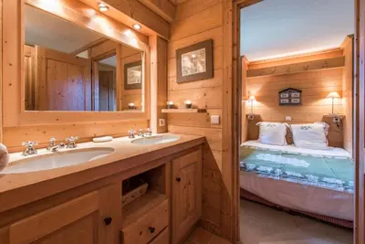 a bathroom with a sink and a mirror and a bed at Loue chalet Megève proximité pistes Rochebrune et centre-ville in Megève