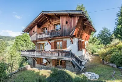 a large wooden house with a balcony on a hill at Loue chalet Megève proximité pistes Rochebrune et centre-ville in Megève