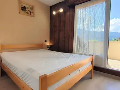 a bedroom with a bed and a large window at Appartement T3 familial rénové à Samoëns, animaux acceptés - FR-1-624-161 in Samoëns