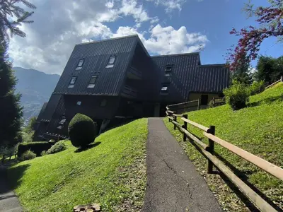 a black house on a hill with a fence at Appartement T3 familial rénové à Samoëns, animaux acceptés - FR-1-624-161 in Samoëns