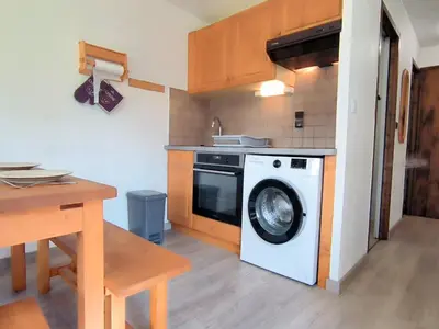 a kitchen with a washing machine and a table at Appartement T3 familial rénové à Samoëns, animaux acceptés - FR-1-624-161 in Samoëns