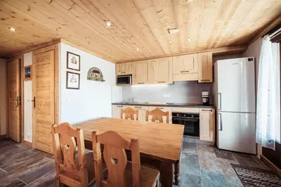 a kitchen with a wooden table and a refrigerator at Flat Sofia - Authentic charm in Demi-Quartier