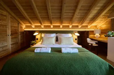 a bedroom with a large green bed with two pillows at Chalet Piccolo - OVO Network in Saint-Gervais-les-Bains