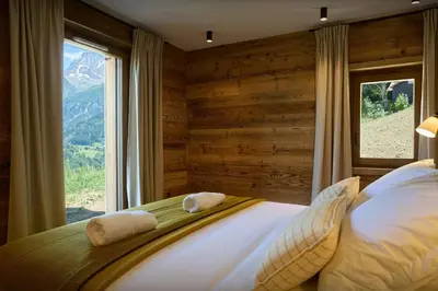a bedroom with a large bed with a window at Chalet Piccolo - OVO Network in Saint-Gervais-les-Bains