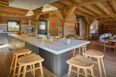 a kitchen with a large island with wooden stools at Chalet Piccolo - OVO Network in Saint-Gervais-les-Bains