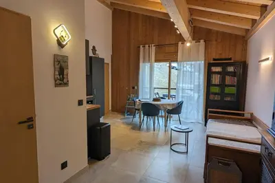 a living room with a table and a dining room at Appartement ludothèque familial neuf à Combloux in Combloux