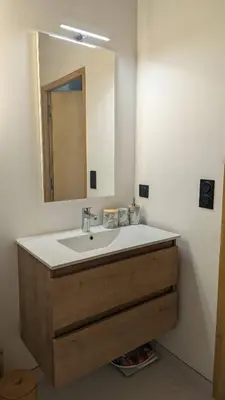 a bathroom with a sink and a mirror at Appartement ludothèque familial neuf à Combloux in Combloux