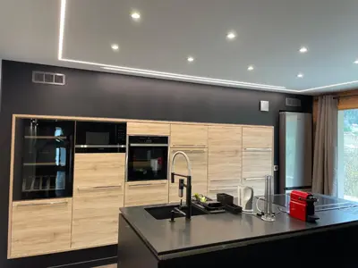 a kitchen with wooden cabinets and a black counter top at Chalet Cristal I in Les Contamines-Montjoie