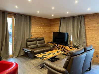 a living room with two chairs and a flat screen tv at Chalet Cristal I in Les Contamines-Montjoie