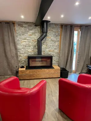 a living room with two red chairs and a fireplace at Chalet Cristal I in Les Contamines-Montjoie