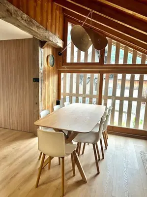 a wooden table and chairs in a room at Le tilleul-cœur du village in Samoëns