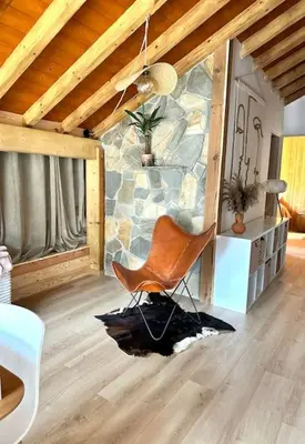 a chair in a room with a stone wall at Le tilleul-cœur du village in Samoëns