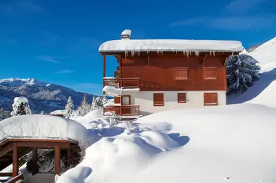a wooden building covered in snow with snow at Exceptional view of village and mountain in Megève