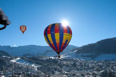 two hot air balloons are flying over a city at Exceptional view of village and mountain in Megève