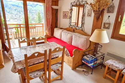 a living room with a table and a couch at Exceptional view of village and mountain in Megève