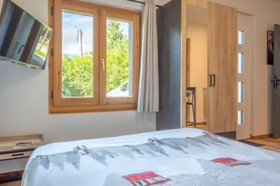 a room with a bed with a window and a television at Studio Miloé secteur TMB in Saint-Gervais-les-Bains