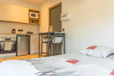 a small room with a bed and a kitchen at Studio Miloé secteur TMB in Saint-Gervais-les-Bains