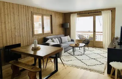 a living room with a couch and a table at Magnifique appartement au coeur de Megève in Megève