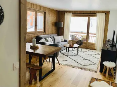 a kitchen with a wooden table and some chairs at Magnifique appartement au coeur de Megève in Megève