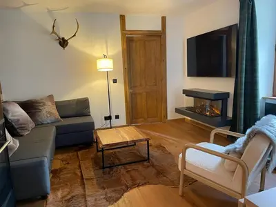 a living room with a fireplace with a tv above it at Chalet OurSouris in Saint-Gervais-les-Bains
