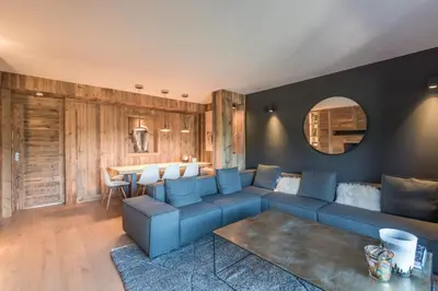 a living room with a blue couch and a table at Appartement de Charvin - Welkeys in Megève