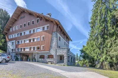a large building with a car parked in front of it at Appartement de Charvin - Welkeys in Megève