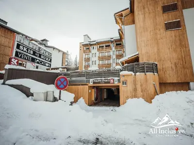 a building covered in snow with a street sign at Charmant Studio - Moderne - Proche centre in Megève