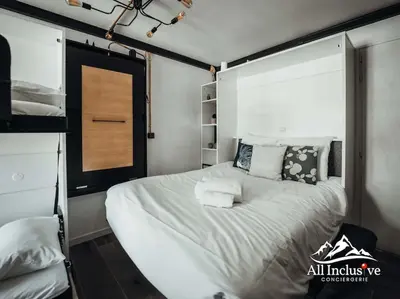 a bedroom with a large white bed with pillows at Charmant Studio - Moderne - Proche centre in Megève