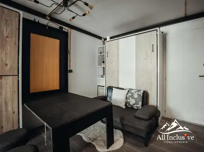 a living room with a table and a chair at Charmant Studio - Moderne - Proche centre in Megève