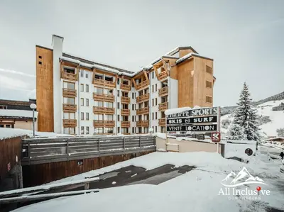 a building with a sign in front of it in the snow at Charmant Studio - Moderne - Proche centre in Megève