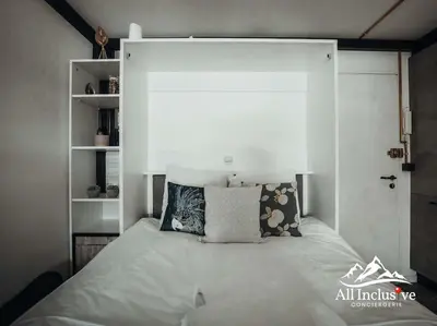 a bed with pillows on it in a bedroom at Charmant Studio - Moderne - Proche centre in Megève