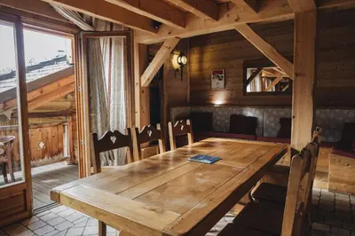 a dining room with a wooden table and chairs at La table de Fifine - Montagne - Appartement 65m2 in Samoëns
