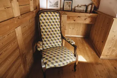 a chair in a room with wooden walls and wooden floors at La table de Fifine - Montagne - Appartement 65m2 in Samoëns