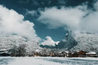 a snow covered mountain with houses in the foreground at La table de Fifine - Montagne - Appartement 65m2 in Samoëns