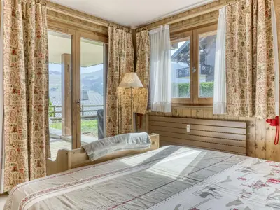 a bedroom with a bed and a large window at Appartement cosy avec terrasse à Megève, idéal pour 2 à 3 personnes - FR-1-453-317 in Megève