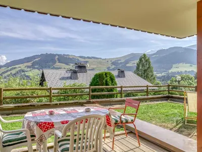 a table and chairs on a deck with a view of mountains at Appartement cosy avec terrasse à Megève, idéal pour 2 à 3 personnes - FR-1-453-317 in Megève