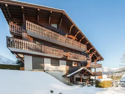 a building with a balcony in the snow at Appartement cosy avec terrasse à Megève, idéal pour 2 à 3 personnes - FR-1-453-317 in Megève