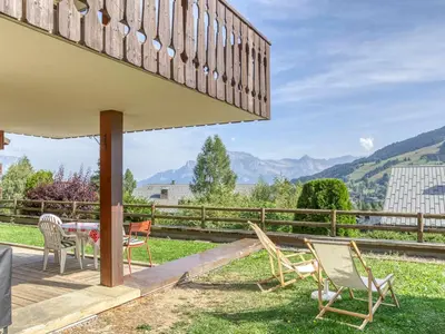 a patio with chairs and a table with a view of mountains at Appartement cosy avec terrasse à Megève, idéal pour 2 à 3 personnes - FR-1-453-317 in Megève