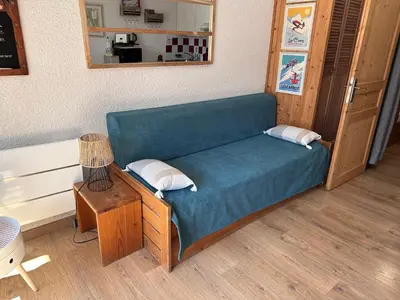 a blue couch in a room with a table at Les Cîmes des Carroz in Les Carroz d'Araches