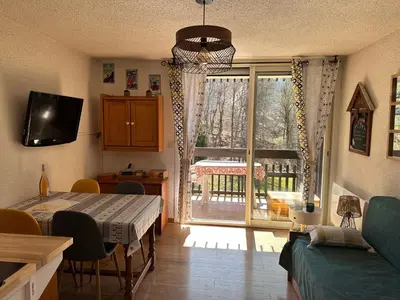 a living room with a table and a sliding glass door at Les Cîmes des Carroz in Les Carroz d'Araches