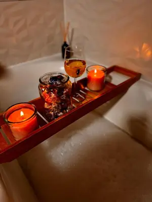 a tray with candles and two glasses on a bath tub at Les Cîmes des Carroz in Les Carroz d'Araches