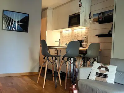 a kitchen with a table and chairs in a room at Studio confortable rénové en résidence verdoyante à Chamonix - FR-1-517-69 in Chamonix-Mont-Blanc